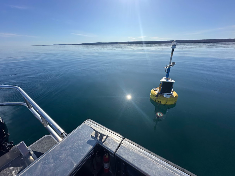 NexSens data buoy deployed at the Keweenaw North Entry (NDBC 45023). The northern shoreline of the Keweenaw Peninsula is in the background.