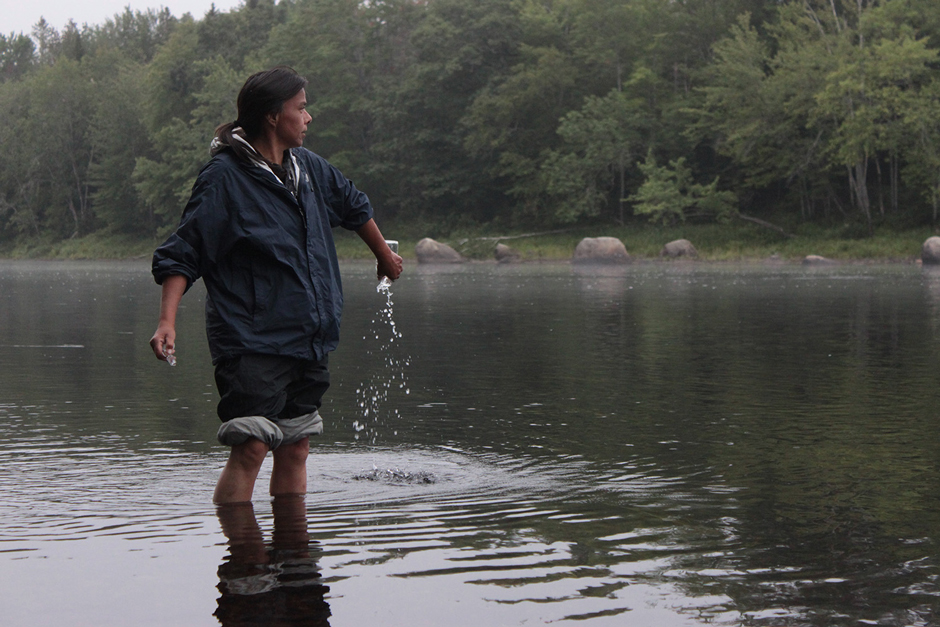Jan Paul, Penobscot Nation citizen, rinsing bottle before collecting sample.
