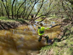 Hydrologic Technician Matthew Bach making a discharge measurement using an acoustic velocimeter at the Ashwaubenon Creek near Little Rapids, WI.