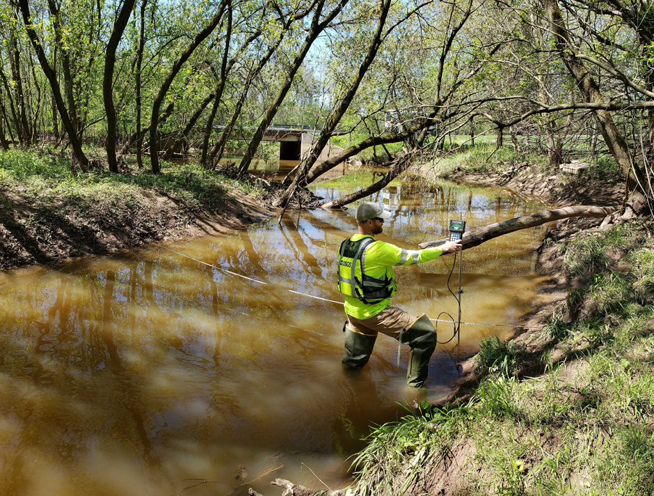 Hydrologic Technician Matthew Bach making a discharge measurement using an acoustic velocimeter at the Ashwaubenon Creek near Little Rapids, WI.
