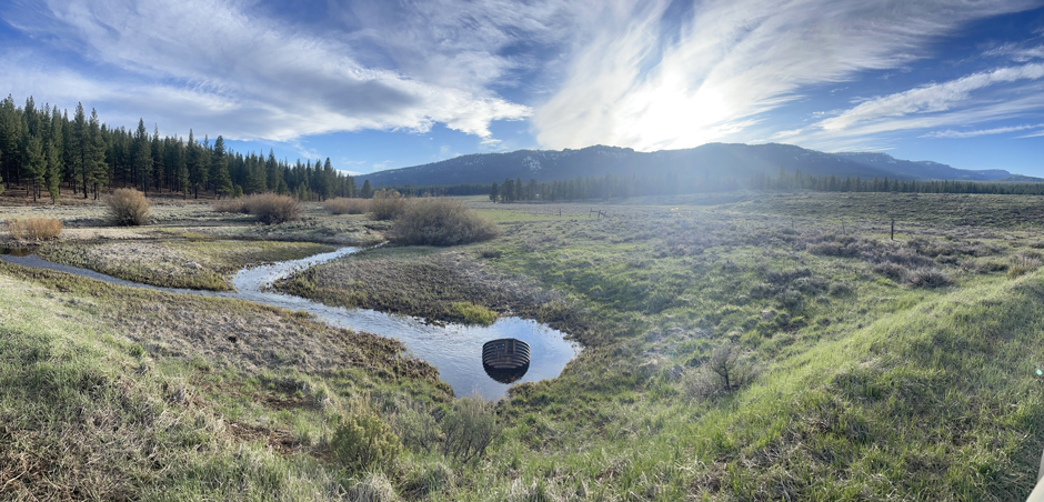A picture of the Dog Valley meadow and the mountains on the western edge of the watershed at a crossing over the mainstem of Dog Creek in April 2025.