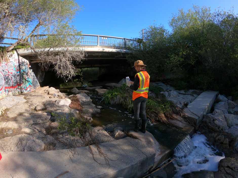 Shepherd samples for bacteria as part of the Creeks Division’s biweekly sampling protocol on Arroyo Burro Creek at Cliff Drive.
