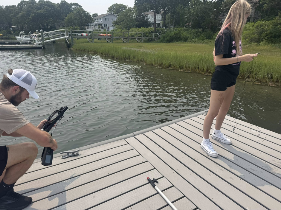 PWSA interns Olivia Posk and Robert Hokanson assembling settling plates to be suspended off a dock in Popponesset Bay.